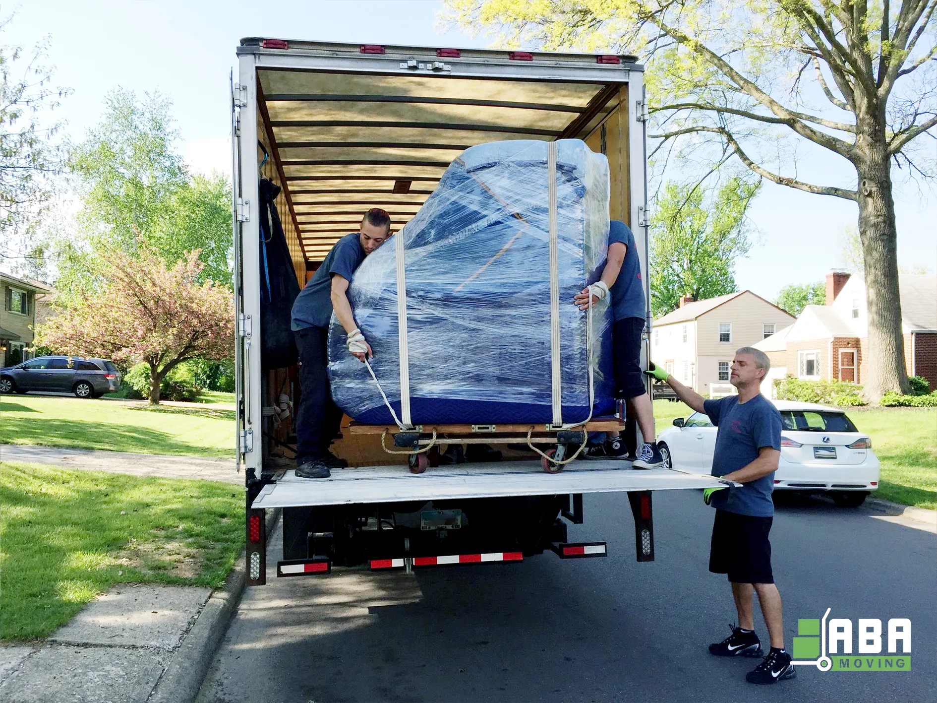 Piano Moving Team Members Unloading Instrument from Truck